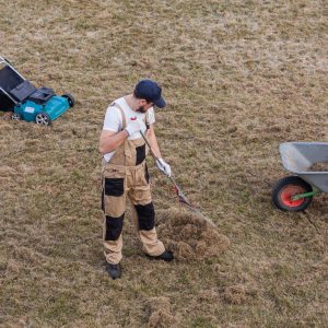 scarifying-lawn-with-rake-scarifier-man-gardener-scarifies-lawn-removal-old-grass-min-scaled-1.jpg